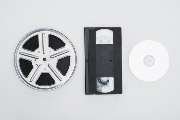 top view of film reel, VHS cassette and CD disc on white background - Photo, Image