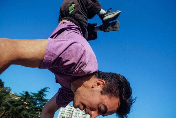 Fizikailag erős férfi tartja a testét a kezén egy skatepark - Fotó, kép