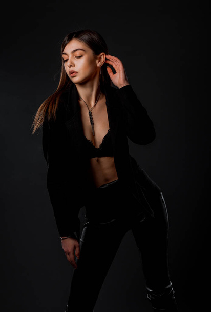 Portrait of an attractive stylish woman posing against dark background - Foto, Imagen