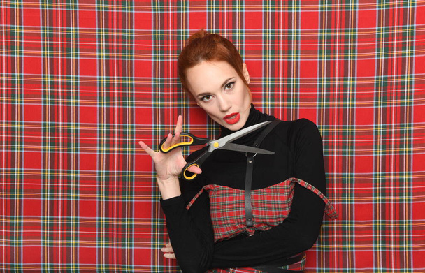 Redhead girl in red checkered dress with scissors - Zdjęcie, obraz