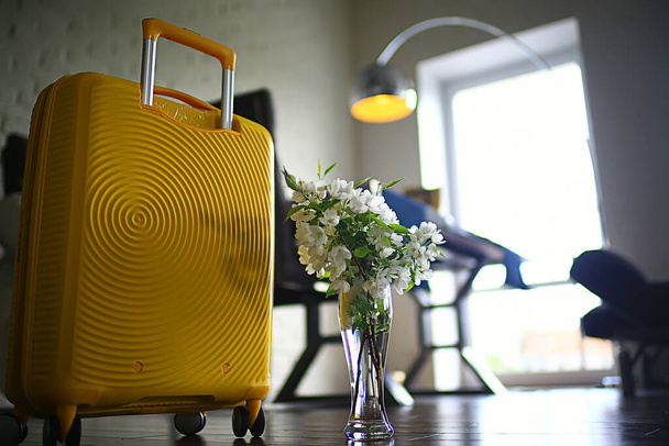 spring trip, a bouquet of flowers of an apple tree and a yellow suitcase - Photo, image