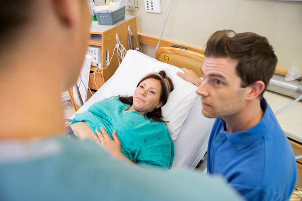 Pregnant Woman And Husband Looking At Nurse In Hospital - Zdjęcie, obraz