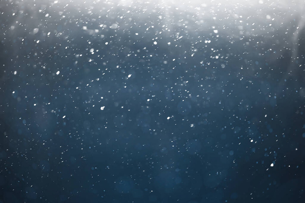 blue snowfall bokeh background, abstract snowflake background on blurred abstract blue - 写真・画像
