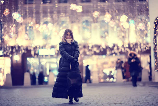 κορίτσι Χριστούγεννα φώτα βράδυ διακοσμημένα πόλη, ένα νεαρό μοντέλο στο παρασκήνιο της αστικής διακοσμήσεις και γιρλάντες, φώτα της πόλης νύχτα - Φωτογραφία, εικόνα