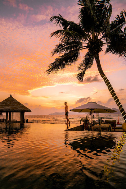 Piscina de lujo en complejo tropical, vacaciones relajantes en las islas Seychelles. La Digue, Joven al atardecer en la piscina
 - Foto, imagen