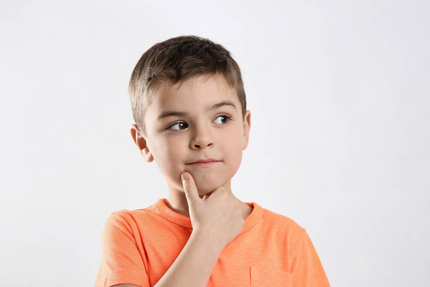 Emotional little boy in casual outfit on white background - 写真・画像