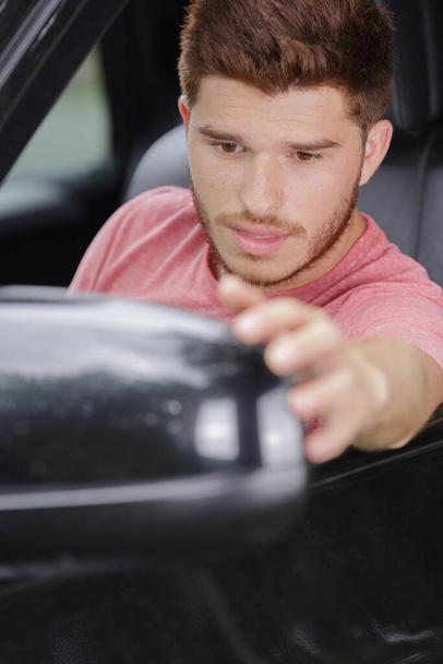 young man checking car side mirror - Фото, зображення