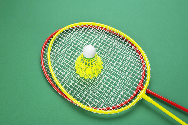 Two shuttlecock and badminton racket. on a green background. Concept summer relaxation.  - Photo, image