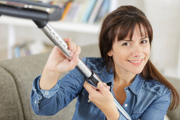 happy woman or housewife with vacuum cleaner at home - Foto, Bild