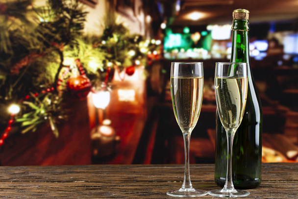 装飾されたクリスマスツリーの背景にガラスのシャンパンのボトル。お正月セットです。テックスの場所 - 写真・画像