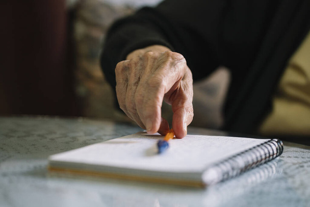 Ηλικιωμένος γράφει στο σημειωματάριό του - Φωτογραφία, εικόνα