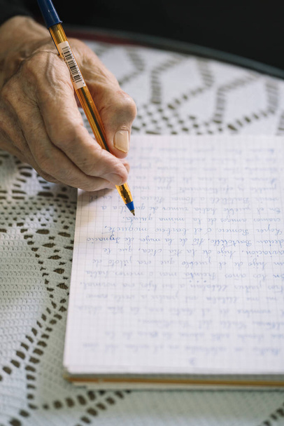 Elderly man writing in his notebook - Фото, зображення