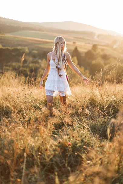 Joven mujer hippie boho bastante vistiendo en estilo rústico descansando en el pueblo, campo, caminando en el campo de verano
 - Foto, imagen