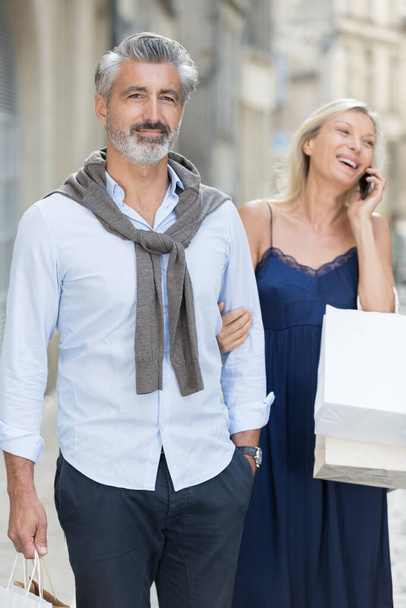mature couple shopping woman laughing on her telephone - Φωτογραφία, εικόνα