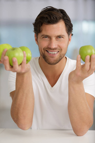 young man holding green apples - 写真・画像