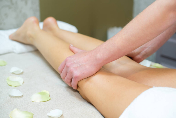 masseur massaging the backs of a womans legs - Photo, Image