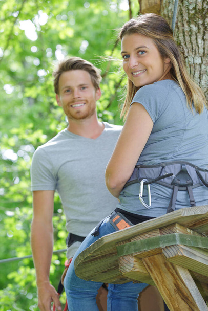 couple wearing harness for forest adventure course - Фото, изображение