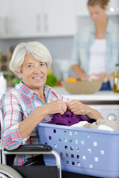 a mature woman doing laundry - Фото, изображение