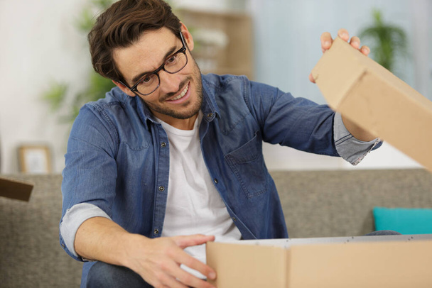 happy man at home opening a cardboard box - Foto, immagini