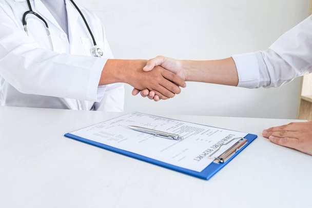 Finishing of consulting, Doctor and patient shaking hands after a good and successful treatment in the hospital, healthcare and assistance concept. - 写真・画像