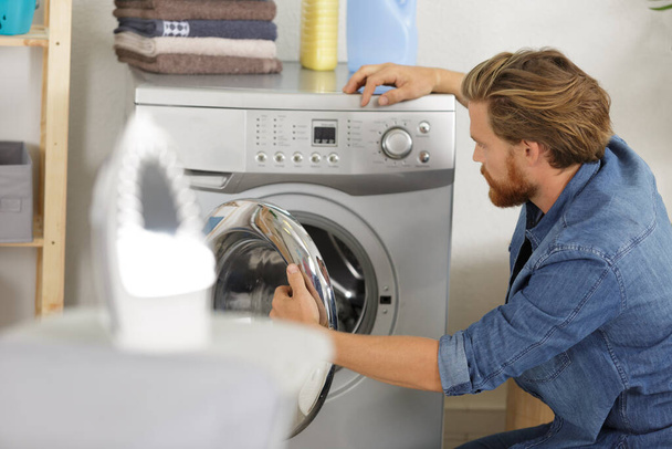 man near the washing machine with laundry basket - Fotoğraf, Görsel