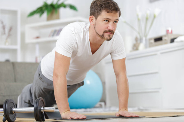 young man doing plank exercise at home - Foto, Imagem