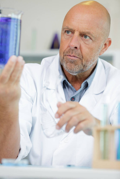 portrait mature man holding test tube at laboratory - Zdjęcie, obraz