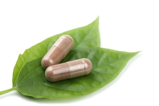 Macro de pílulas de prescrição sobre folha verde isolado
 - Foto, Imagem