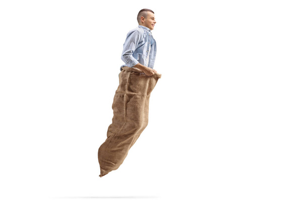 Guy playing a gunny race and jumping with a sack isolated on white background - Φωτογραφία, εικόνα