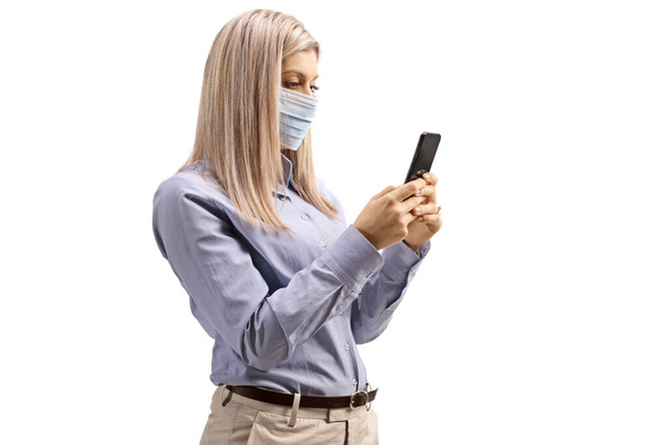 Mujer con máscara médica y tecleando en un teléfono móvil aislado sobre fondo blanco
 - Foto, imagen