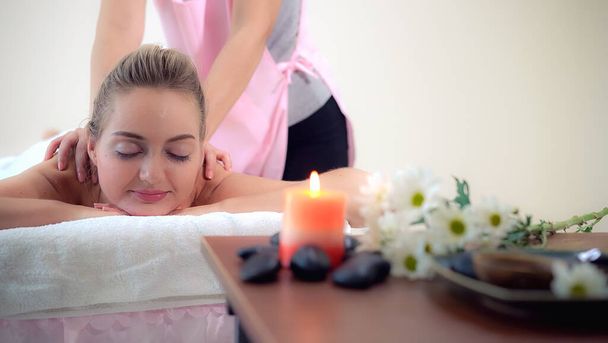 Relaxovaná žena dostává masáž zad v luxusních lázních s profesionálním masážním terapeutem. Wellness, léčebný a relaxační koncept. - Fotografie, Obrázek