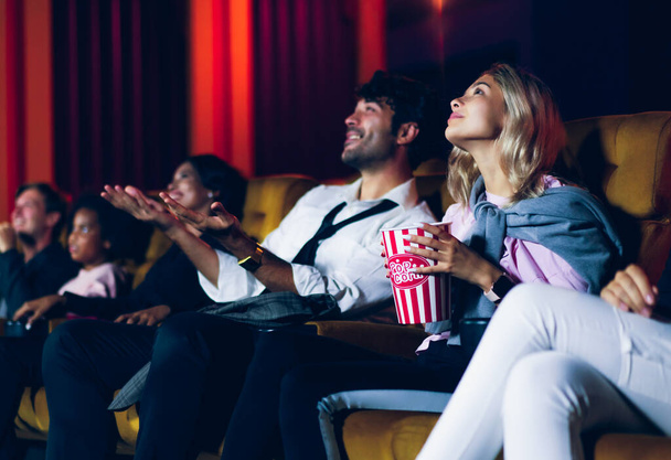 Люди слухають дивитися кіно в кінотеатрі. Групова рекреаційна діяльність та концепція розваг
. - Фото, зображення