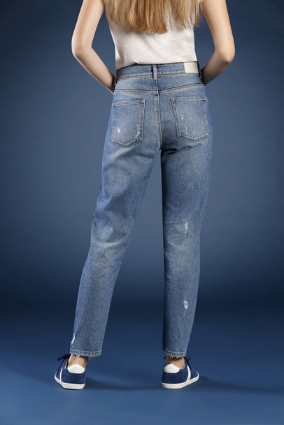 vista cortada de mulher posando em jeans em estúdio, conceito de moda
  - Foto, Imagem