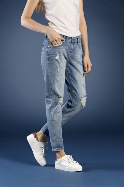 ostříhaný pohled ženy pózující v džínách ve studiu, módní koncept  - Fotografie, Obrázek