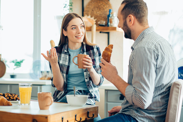 Young woman talking to her boyfriend at the breakfast and gesturing - Foto, Bild