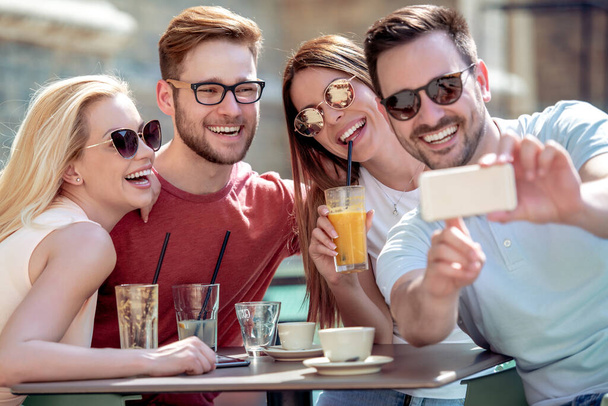 Vrolijke groep vrienden die plezier hebben in cafe, maak selfie foto. - Foto, afbeelding