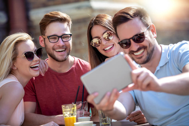 Vrolijke groep vrienden hebben plezier in cafe, het nemen van selfie. - Foto, afbeelding