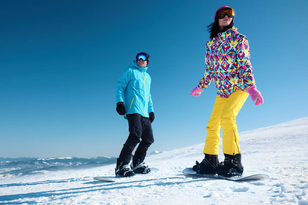Couple snowboarding on snowy hill. Winter vacation - 写真・画像