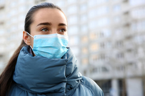 Woman wearing disposable mask outdoors. Dangerous virus - Photo, image