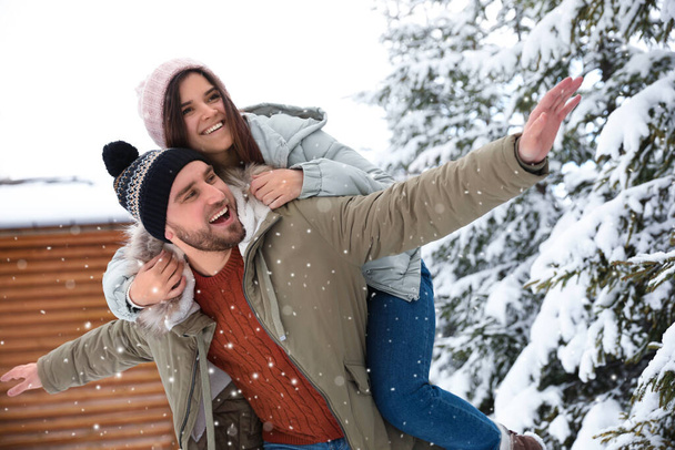 Lovely couple spending time together on snowy day. Winter vacation - Фото, изображение