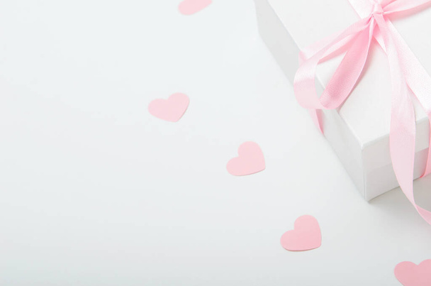 Caja de regalo blanca con cinta rosa y corazones sobre fondo blanco. Regalo de San Valentín, día de la mujer. Copiar espacio
. - Foto, imagen