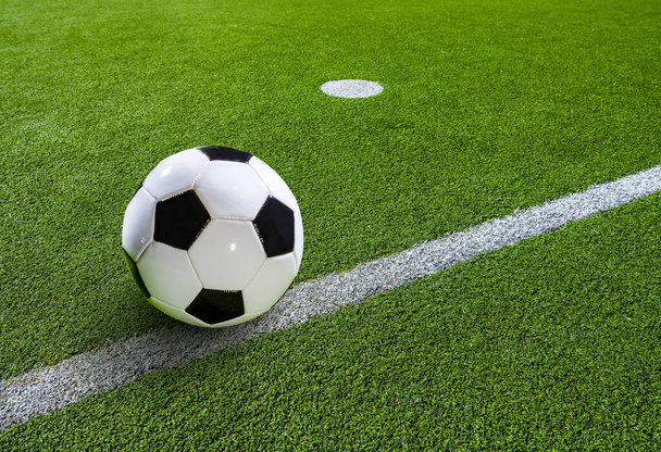 Bola de futebol preto e branco clássica iluminada em um estádio
 - Foto, Imagem