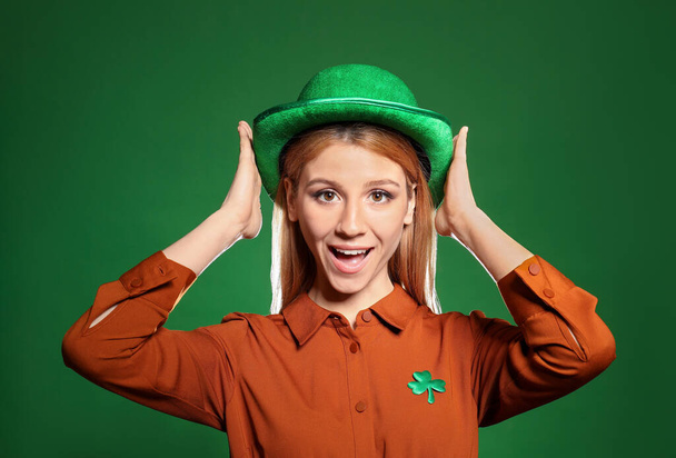 Young woman in green hat on color background. St. Patrick's Day celebration - Zdjęcie, obraz