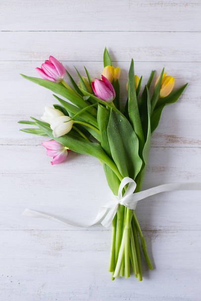Bouquet de tulipes colorées sur fond de bois blanc
 - Photo, image