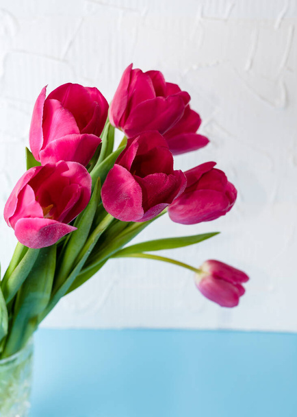 Rózsaszín tulipán csokor egy kristályvázában. Tavaszi virágok. Tavaszi háttér Nemzetközi nőnap és anyák napi háttér. - Fotó, kép