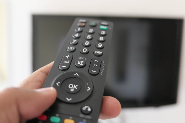 Close up of man hand use Tv remote  - Photo, Image