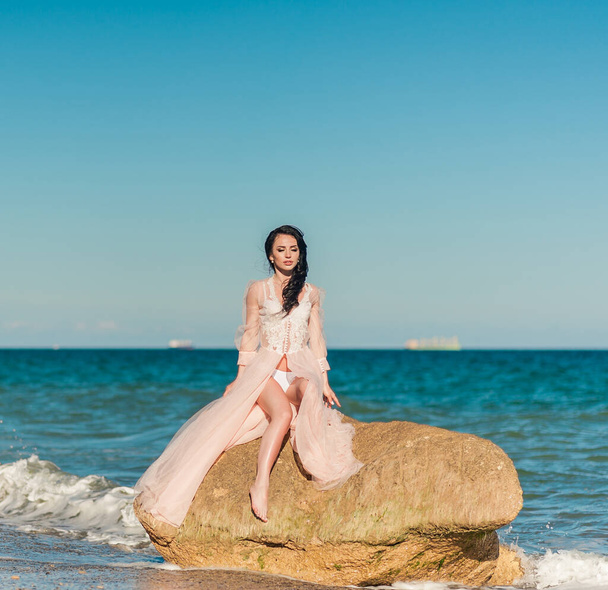 Hermosa novia romántica en vestido de lujo posando en la playa
. - Foto, Imagen