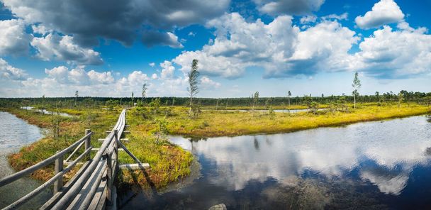 Hermoso sendero entre lagos con reflejo de espejo de cielo nublado en el Parque Nacional Letón Kemeri, Letonia. Vista panorámica
 - Foto, Imagen