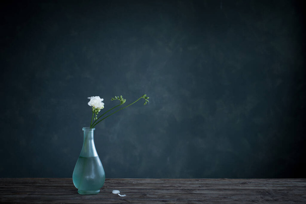 white  freesia in glass vase on dark background - Foto, Imagem