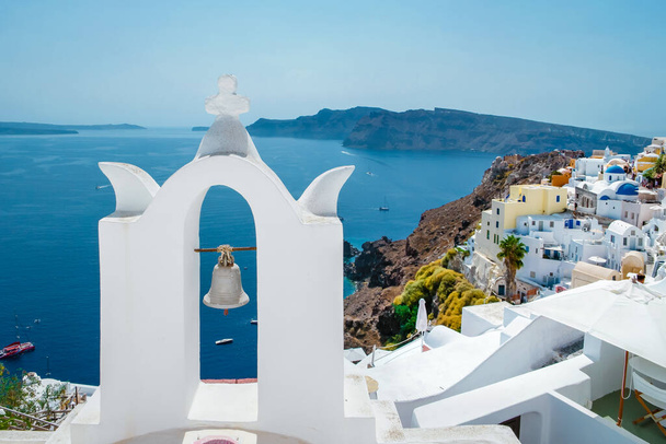 Santorini Oia Köyü günbatımında beyaz oteller ve Santorini Adası 'ndaki beyaz boyalı binalar Yunanistan' da lüks bir tatil beldesi. - Fotoğraf, Görsel
